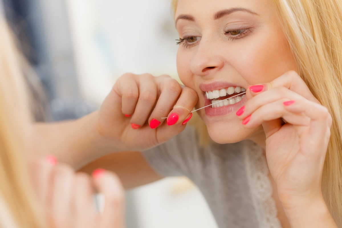 A woman flossing her teeth