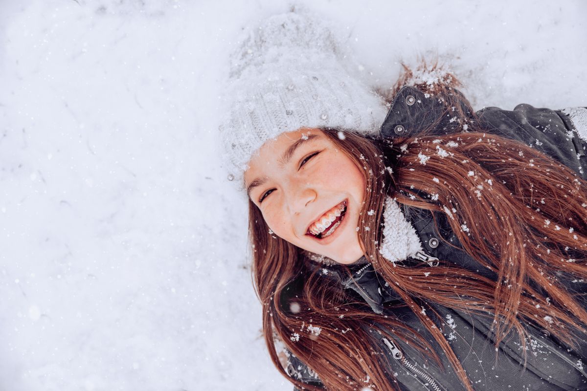 Young woman with long hair laughing and having fun outdoors