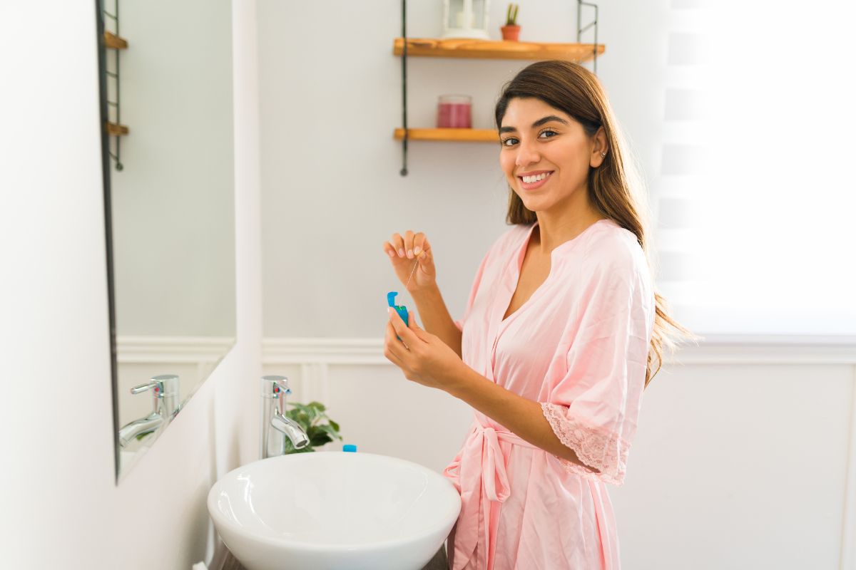 Woman smiling and demonstrating proper brushing and flossing technique
